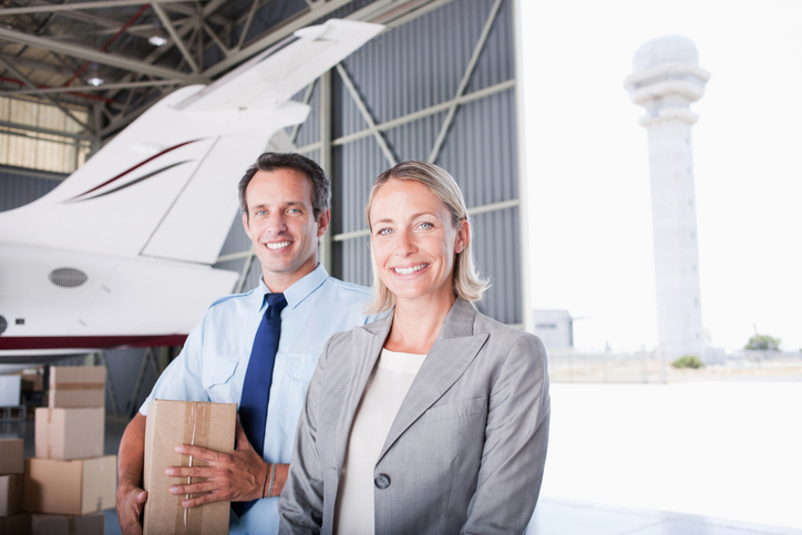 Businesswoman and workers standing in hangar