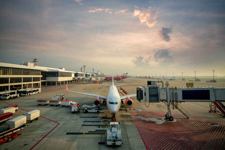 Modern passenger airplane parked to terminal building gate at an airport