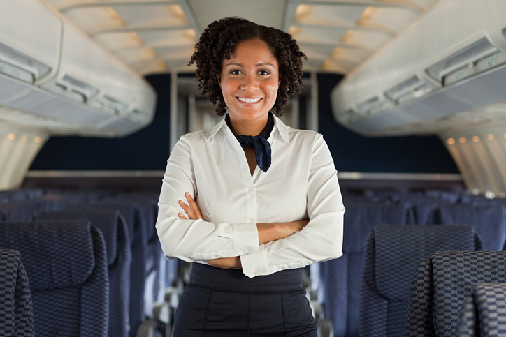 Flight attendant standing in aisle of airplane